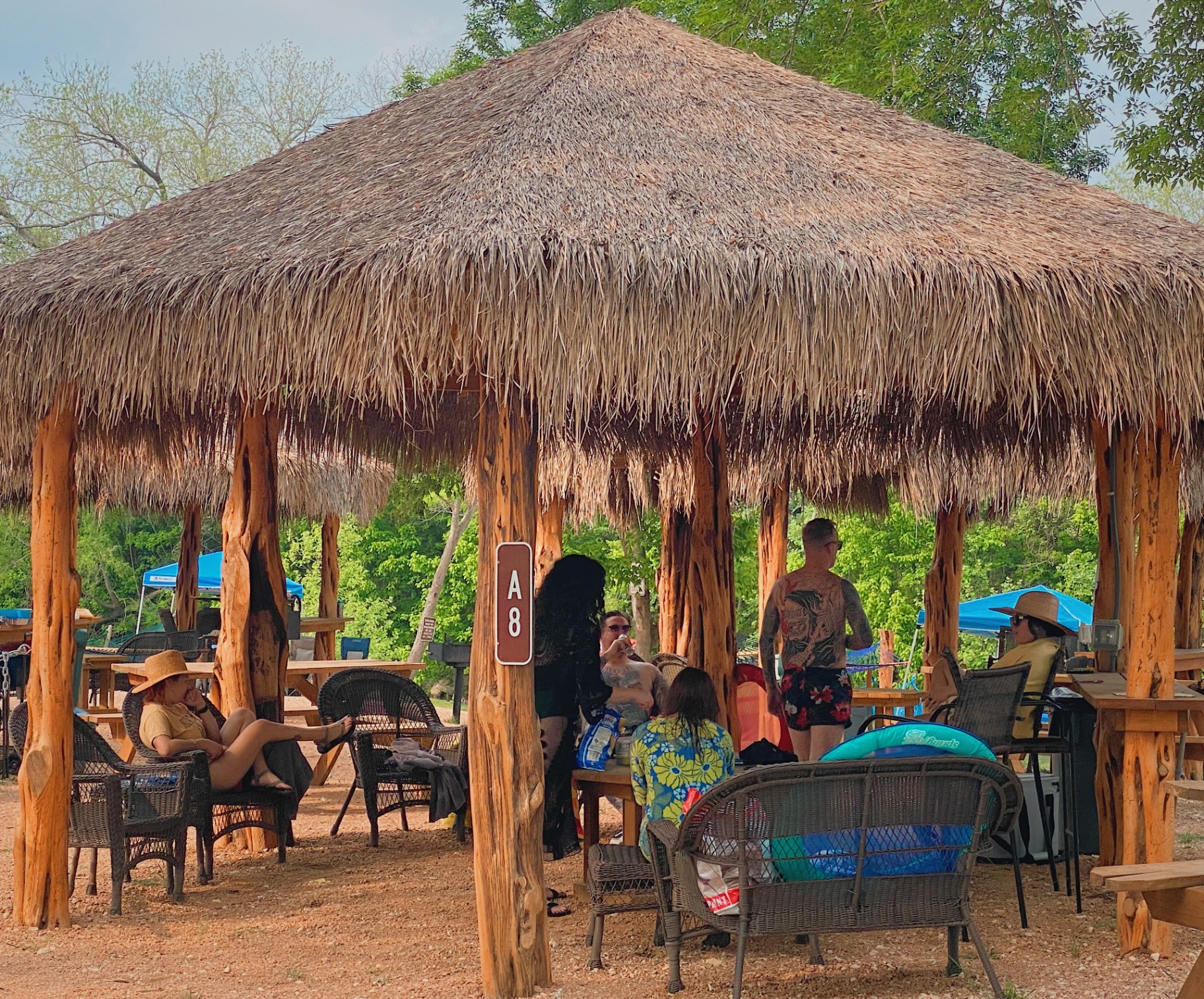 Family relaxing at a riverside cabana at Son's River Ranch