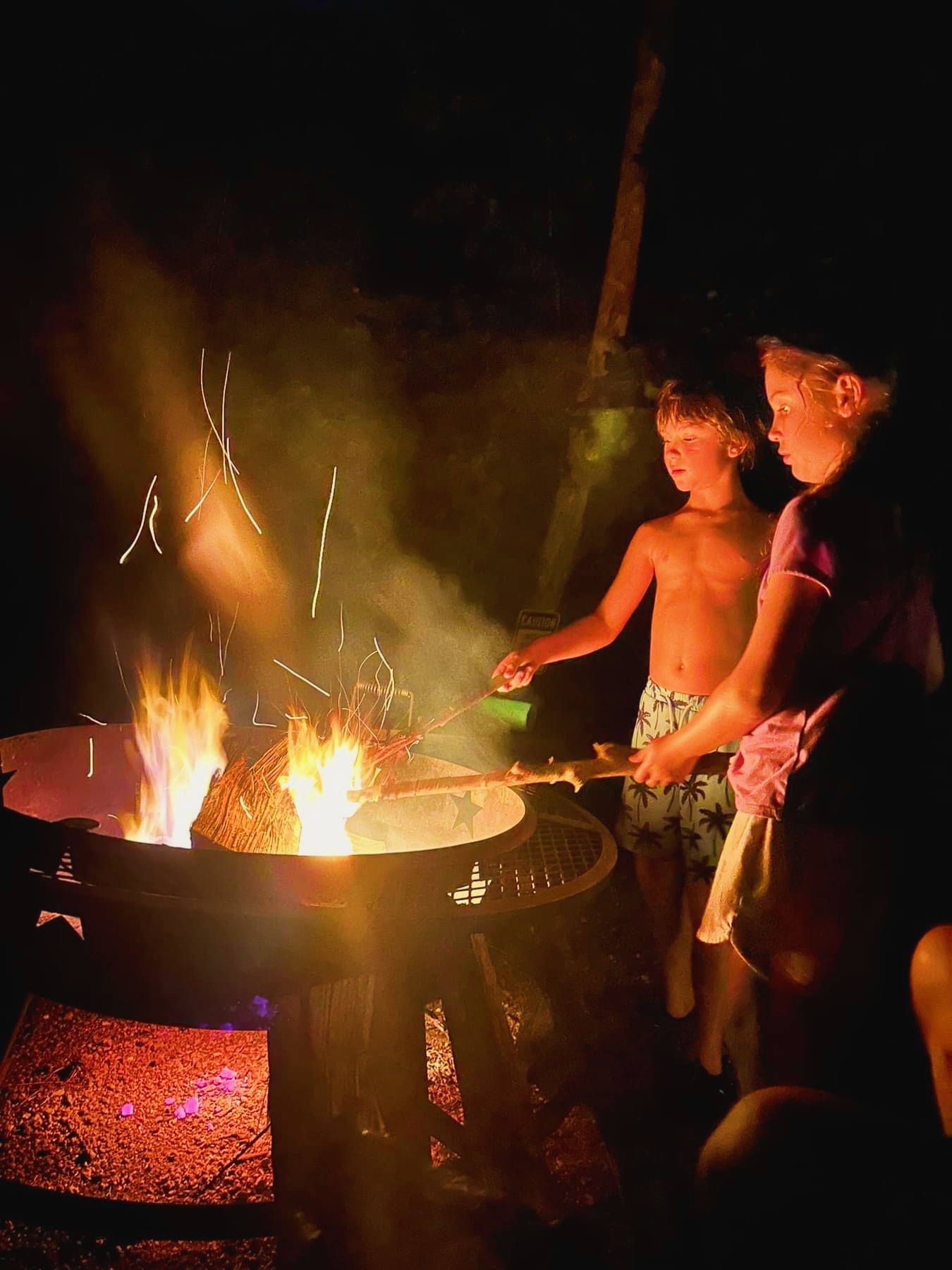 Family gathered around a fire pit at Son's River Ranch in the evening