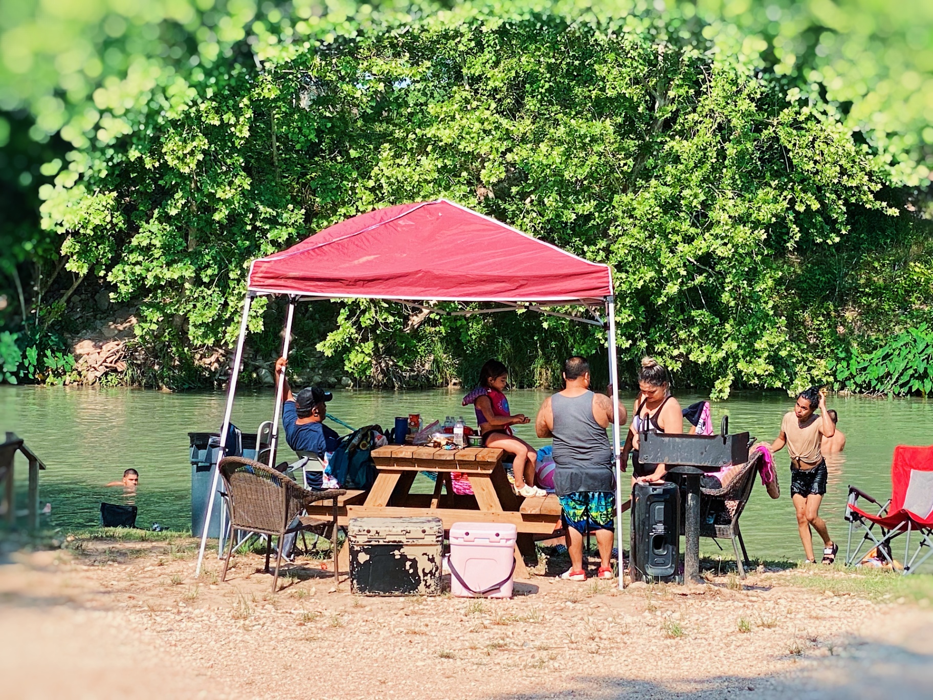 Families enjoying riverside picnic area