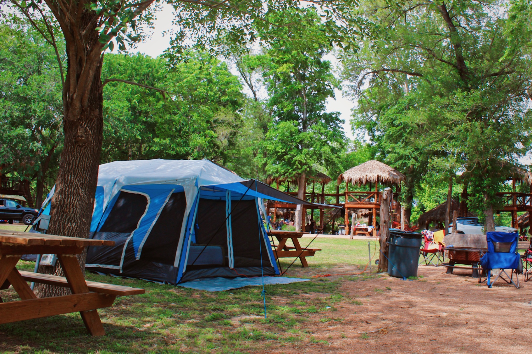 Blue tent with picnic table under trees